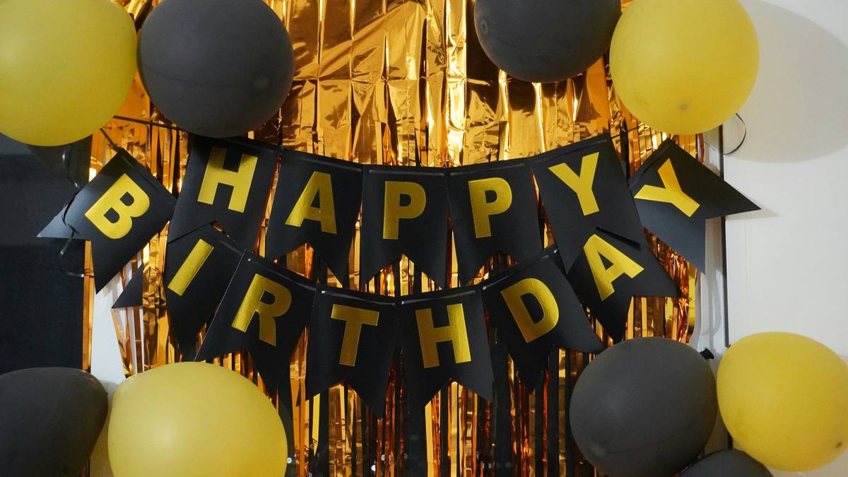 Mood board showing warm string lights, neutral balloons, fresh flowers, and handwritten name cards for home birthday decor