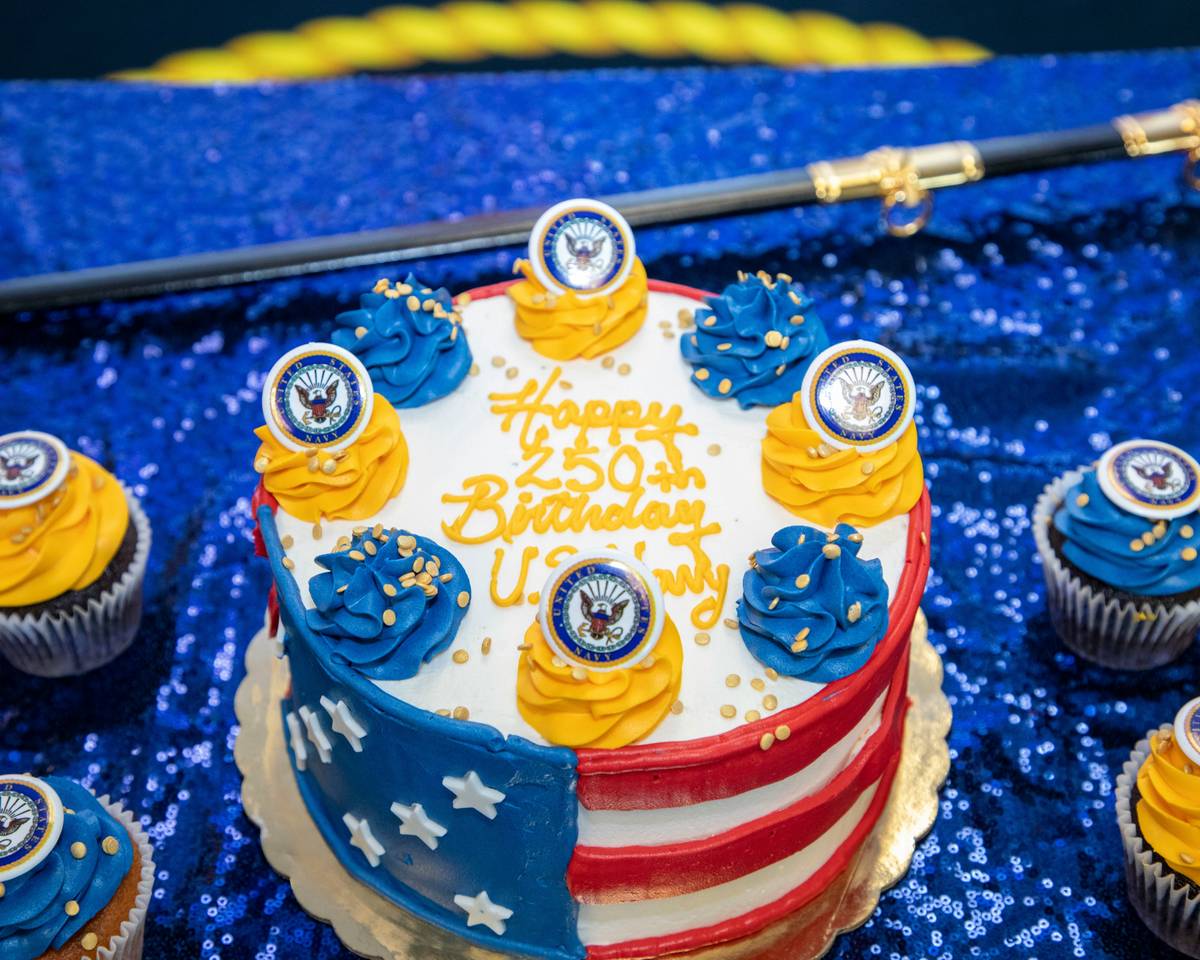 U.S. Army soldiers performing traditional cake-cutting ceremony during Army Birthday event, with ceremonial sword and guests in attendance